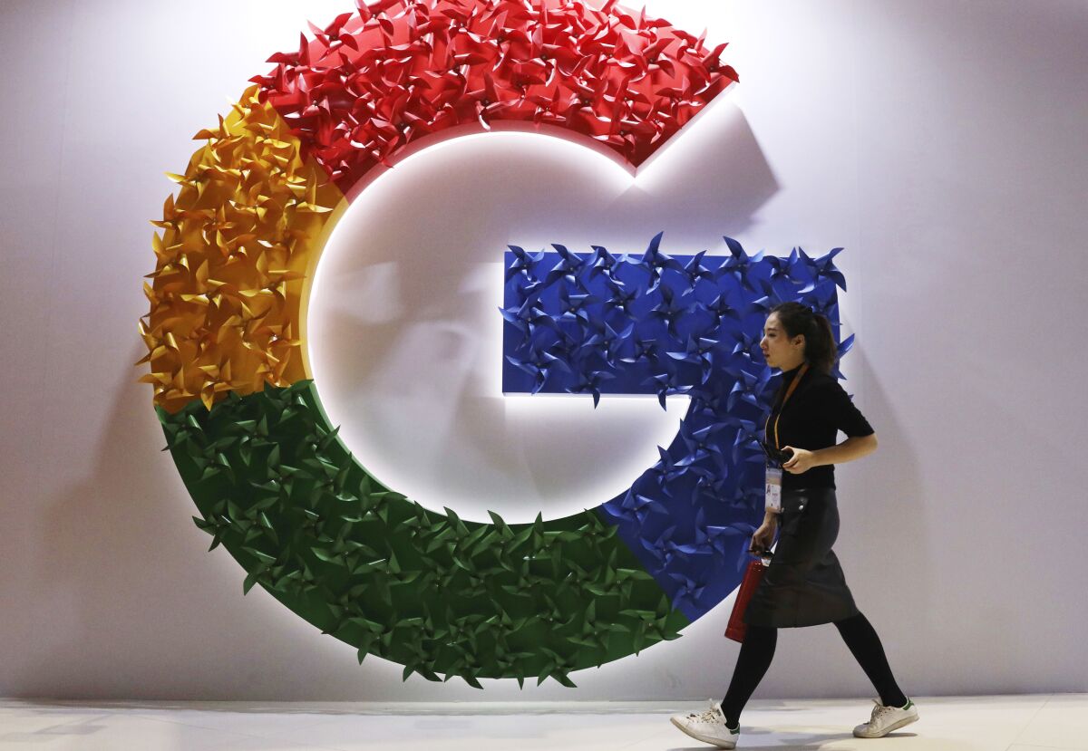 FILE - a woman walks past the logo for Google at the China International Import Expo in Shanghai, Nov. 5, 2018. Google says its Russian subsidiary is planning to file for bankruptcy because it can’t pay staff and suppliers. Russian state media reported Wednesday, May 18, 2022 that the U.S. tech company’s Russian subsidiary submitted notice of its intention to declare bankruptcy to a national registry. (AP Photo/Ng Han Guan, File)