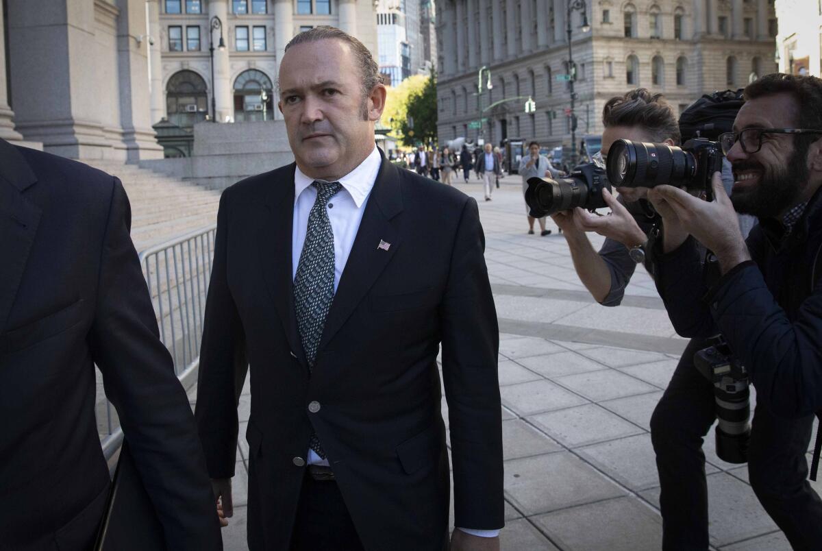 Igor Fruman outside a building while photographers take his picture