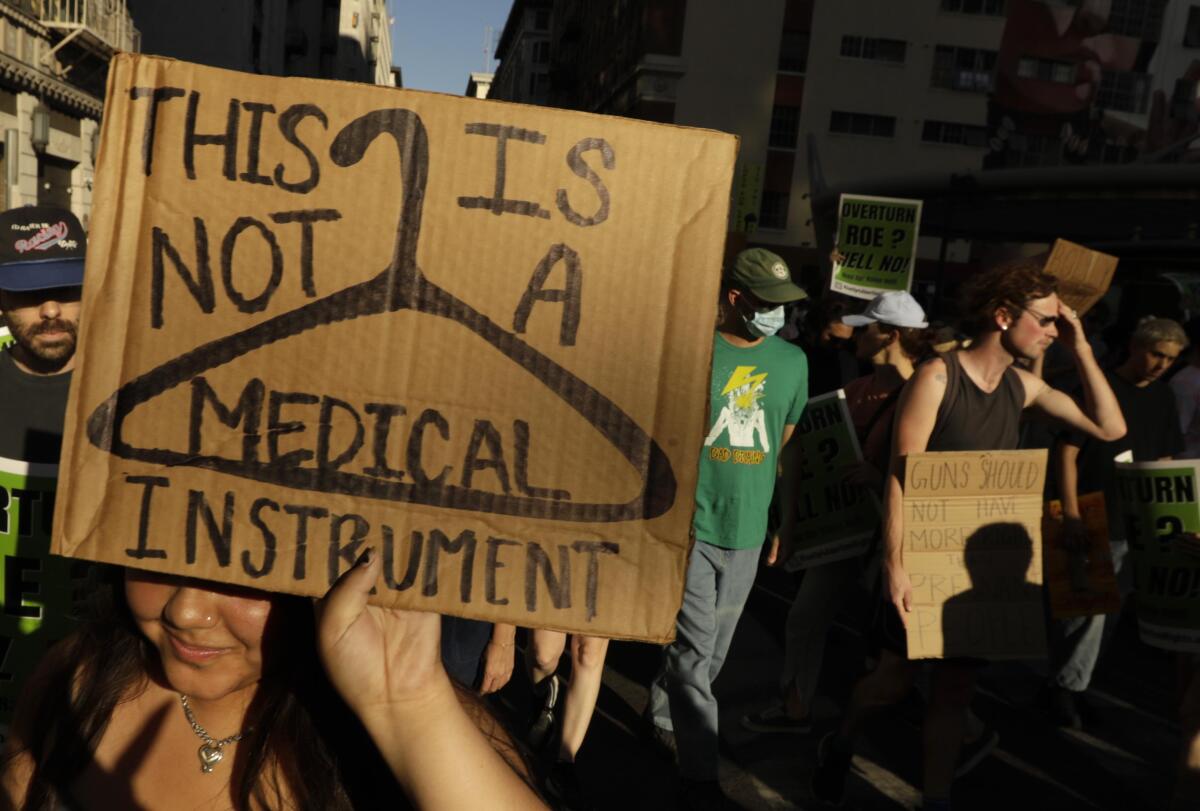 A crowd of people with signs marching in downtown Los Angeles