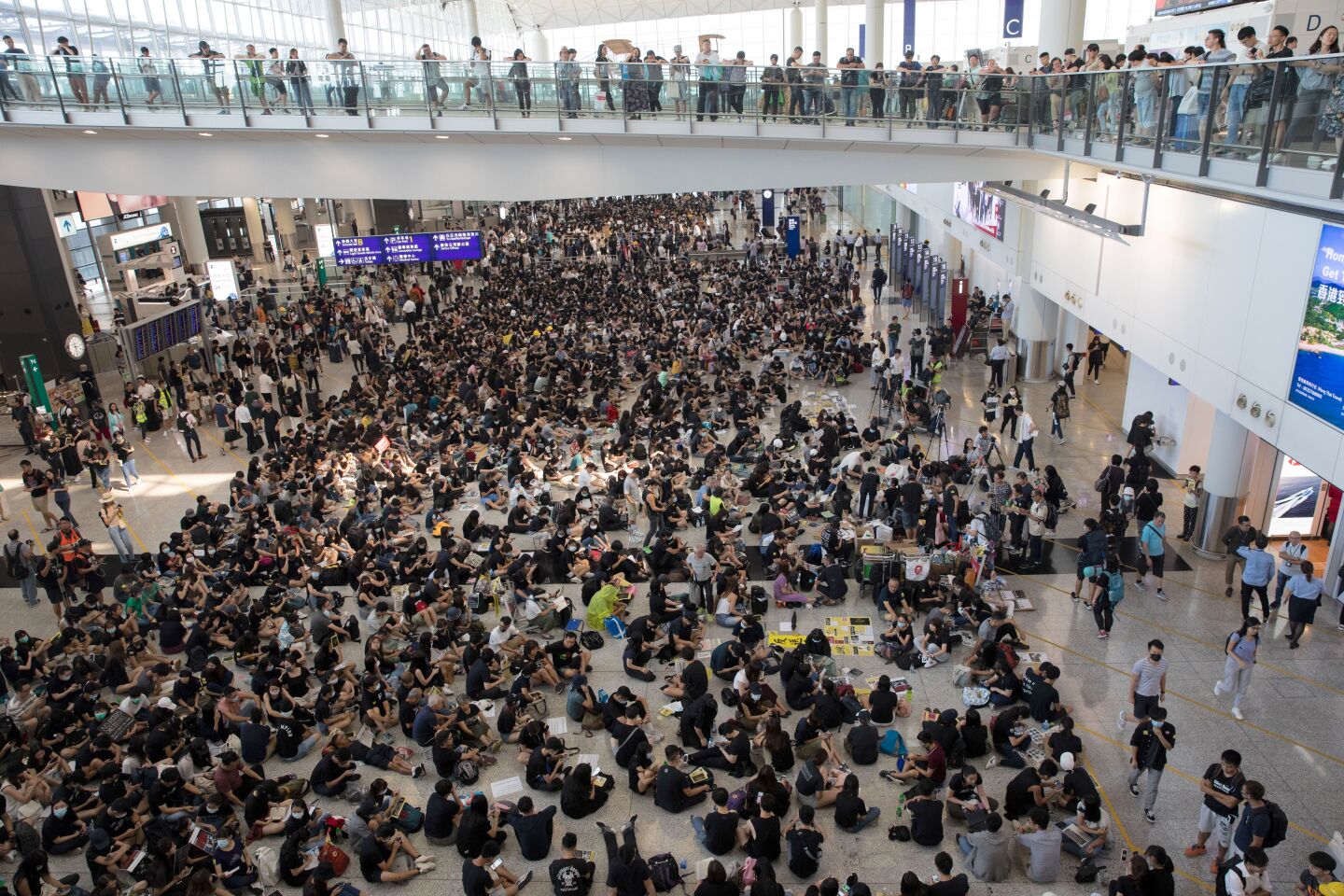Mandatory Credit: Photo by JEROME FAVRE/EPA-EFE/REX (10358133f) Protesters rally inside the arrivals hall of Hong Kong International Airport in Hong Kong, China, 09 August 2019. Protesters were gathering at the airport for a three-day sit-in to protest against a now-suspended extradition bill and call for universal suffrage, and to raise awareness among international visitors to Hong Kong of claims of police brutality. Anti-government protesters rally in Hong Kong airport, China - 09 Aug 2019 ** Usable by LA, CT and MoD ONLY **