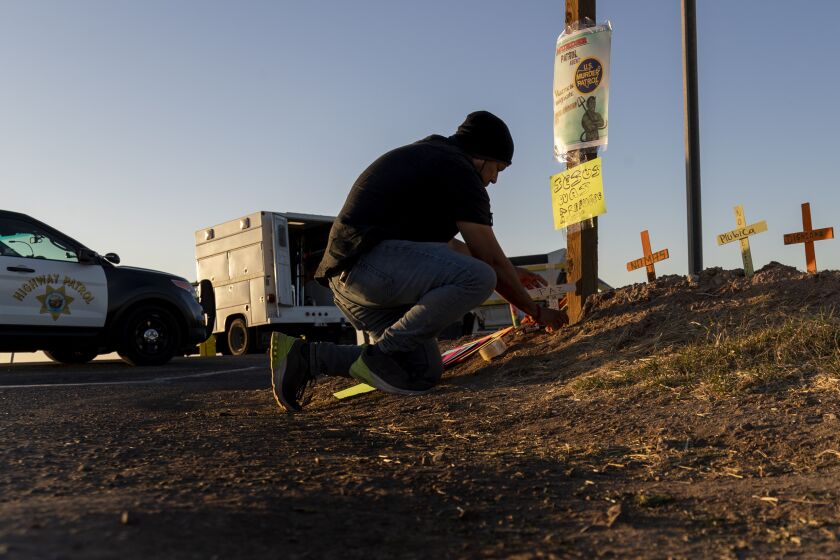 HOLTVILLE, CA - MARCH 2, 2021: Hugo Chavez, an activist with the Coalition for Human Immigration Rights, places crosses at the scene where an SUV carrying 25 people collided with a semi-truck killing 13 on Highway 115 near the Mexican border on March 2, 2021 in Holtville, California. All the back seats had beens stripped from the vehicle. The passengers in the SUV ranged in age from 15-53.(Gina Ferazzi / Los Angeles Times)