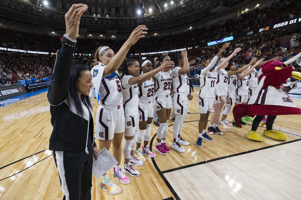 South Carolina's head coach Dawn Staley, far left, celebrates with her players after they defeated UCLA to advance to the Elite Eight following a Sweet 16 college basketball game at the NCAA Tournament in Greenville, S.C., Saturday, March 25, 2023. (AP Photo/Mic Smith)