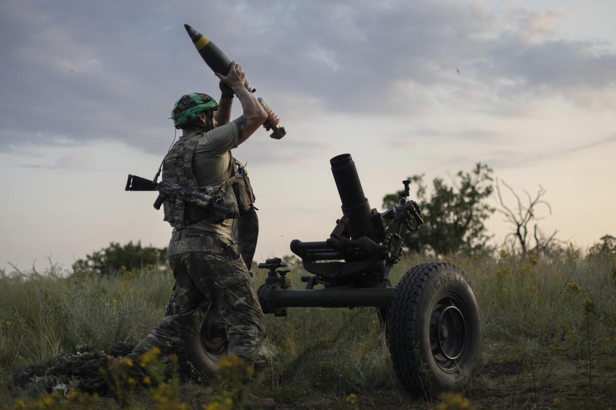 A Ukrainian serviceman loads a mortar shell