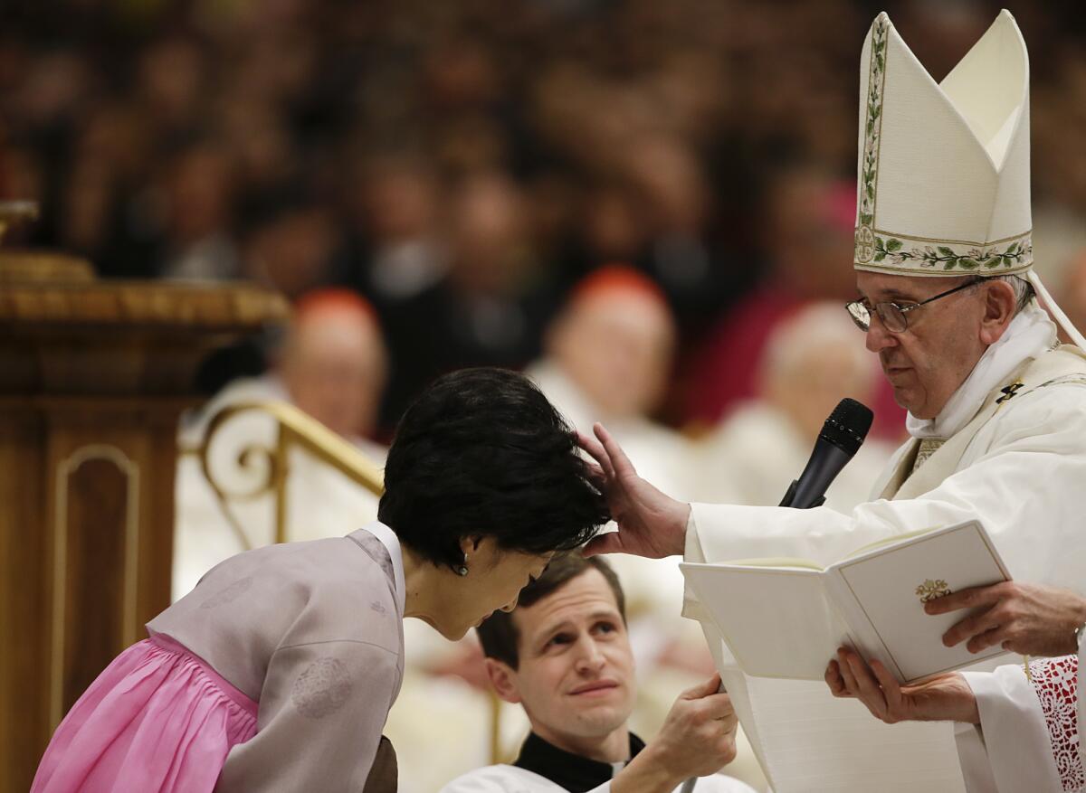 El papa Francisco bautiza como Stella a la surcoreana Hee Kim durante una ceremonia de vigilia pascual en la Basílica de San Pedro, en el Vaticano. (AP Foto/Gregorio Borgia)