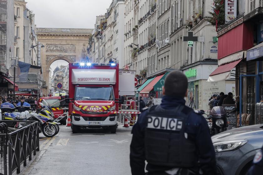 A police officer stands next to the cordoned off area where a shooting took place in Paris, Friday, Dec. 23, 2022. aMultiple people have been wounded and one person arrested after a shooting in central Paris on Friday, authorities said. Police cordoned off the area in the 10th arrondissement of Paris and the Paris police department warned people to stay away from the area. It said one person was arrested, without providing details. (AP Photo/Lewis Joly)