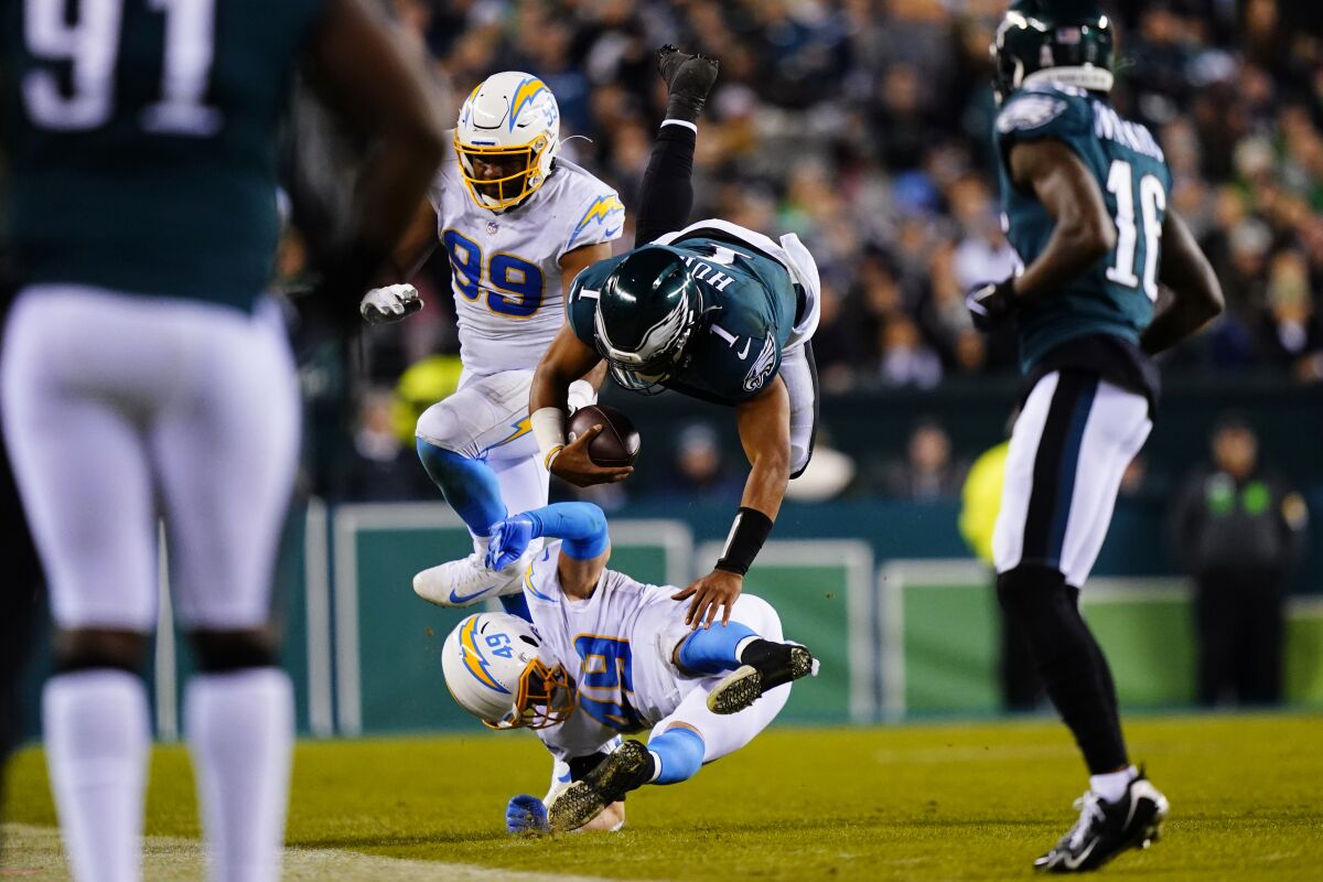 Philadelphia Eagles quarterback Jalen Hurts (1) is stopped by Los Angeles Chargers linebacker Drue Tranquill (49) during the second half of an NFL football game Sunday, Nov. 7, 2021, in Philadelphia. (AP Photo/Matt Slocum)