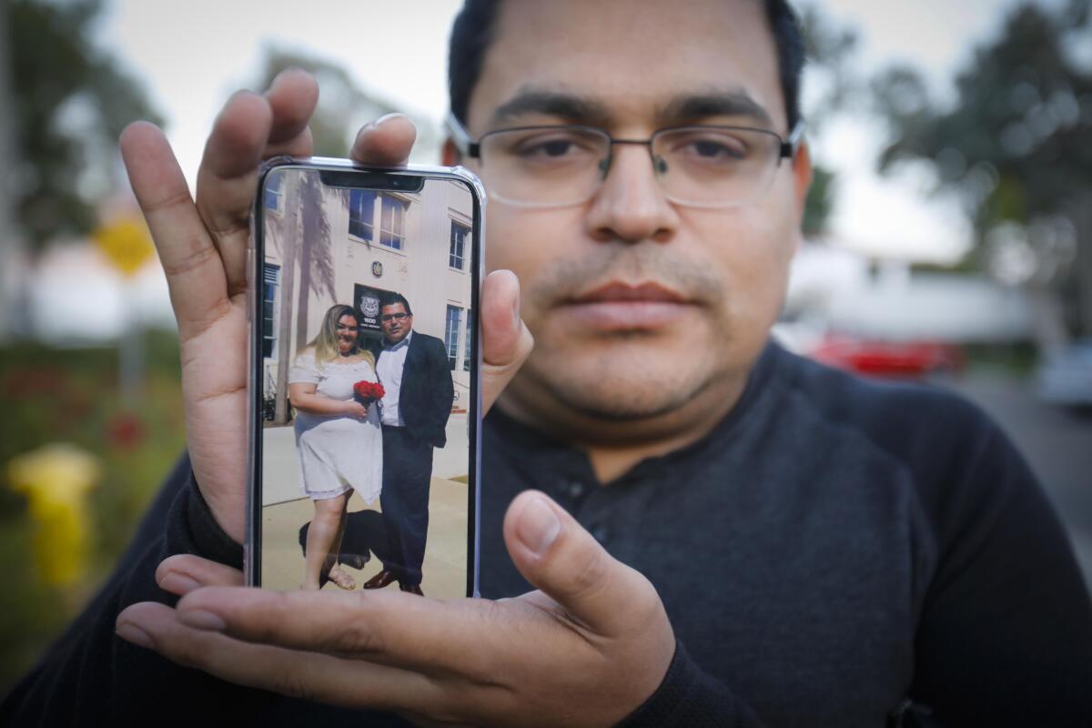 Ramon Mendoza, the husband of Maribel Ibañez, 28, who was killed when a gunman opened fire in the Church's Chicken in Otay Mesa, Wednesday night, holds a cellphone photo showing their wedding day, on March 12th of this year.