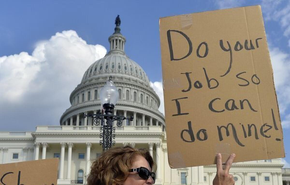 Protesters display placards during a demonstration in front of the U.S. Capitol in Washington on Monday urging Congress to pass the budget bill.
