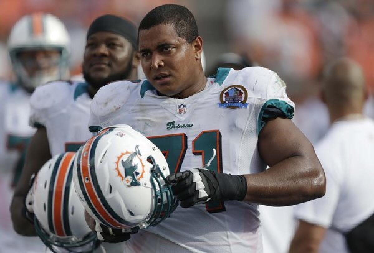 Miami Dolphins tackle Jonathan Martin (71) watches from the sidelines during the second half of an NFL football game against the Jacksonville Jaguars, in Miami.