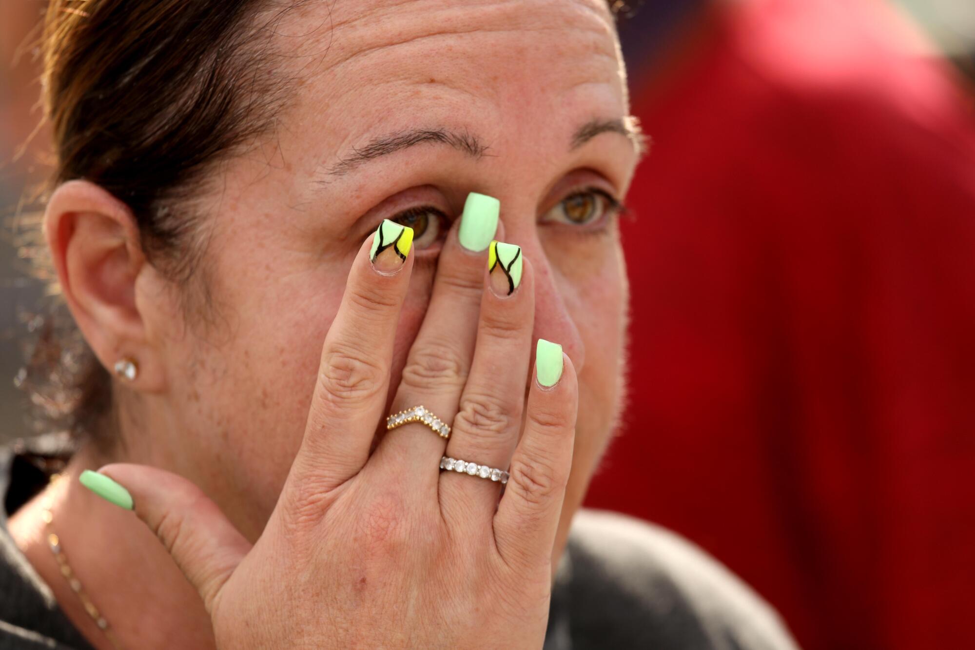 A woman wipes away a tear.