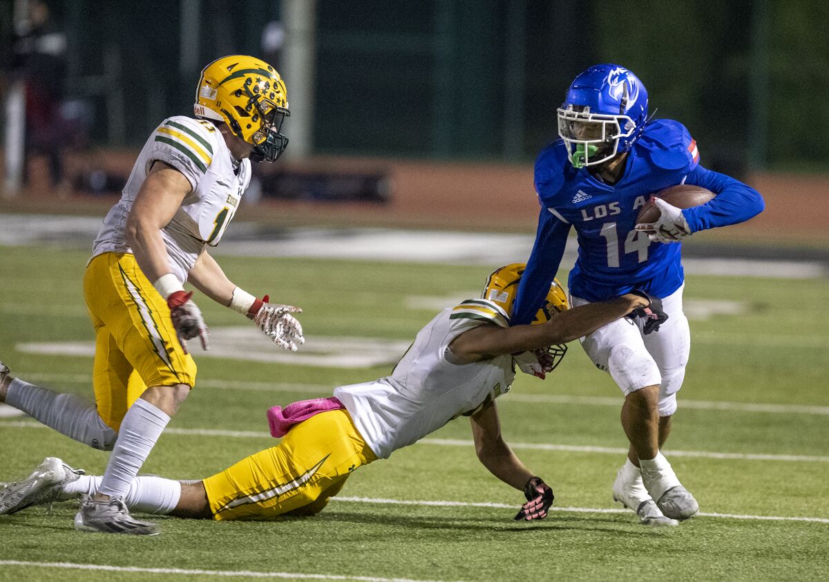 Edison's Malachi Pierce stops Los Alamitos' Makai Lemon during a Sunset League game at Boswell Field on Thursday.