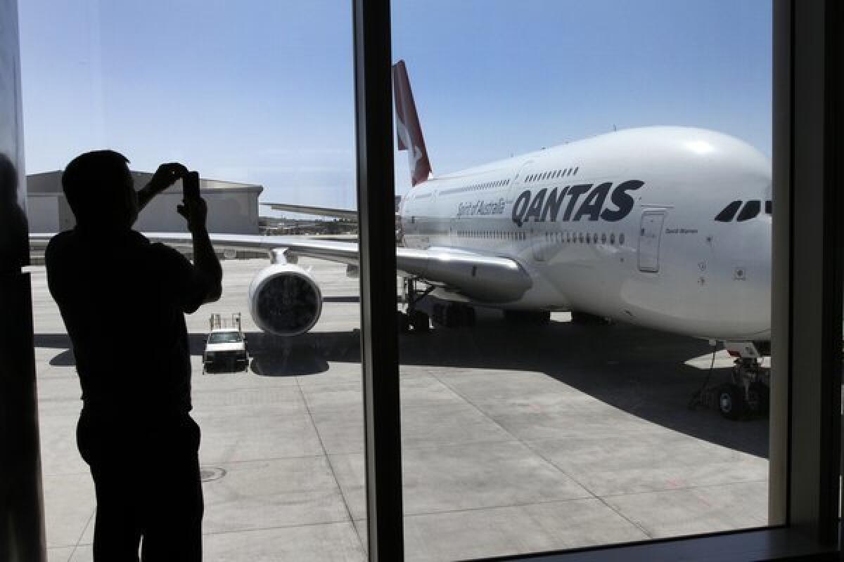 Richard Ryan of Los Angeles uses his smartphone to photograph a Qantas A380 double-decker airplane during the open house. Of the 18 new gates, nine will be able to accommodate such large aircraft.