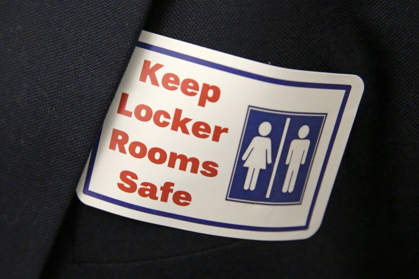 FILE - A sticker that reads, "Keep Locker Rooms Safe," is worn by a person supporting a bill that would eliminate Washington's rule allowing transgender people use gender-segregated bathrooms and locker rooms in public buildings consistent with their gender identity, on Jan. 27, 2016, at the Capitol in Olympia, Wash. On Tuesday, March 21, 2023, Arkansas Gov. Sarah Huckabee Sanders signed a law prohibiting transgender people at public schools from using the restroom that matches their gender identity. Arkansas' law applies to multi-person restrooms and locker rooms at public schools and charter schools serving prekindergarten through 12th grade. (AP Photo/Ted S. Warren, File)