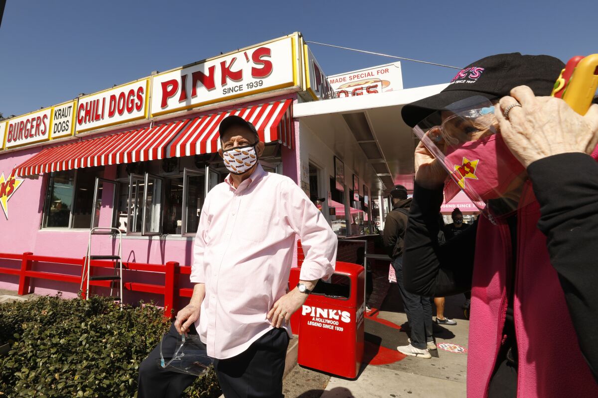 Owners Richard and Gloria Pink stand outside Pink's for the hot dog stand's reopening.