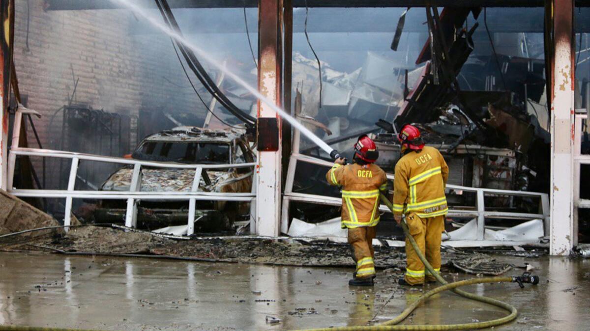 Firefighters with the Orange County Fire Authority put out hot spots after a fire station in Buena Park was destroyed by an early morning blaze. (Mark Boster / Los Angeles Times)