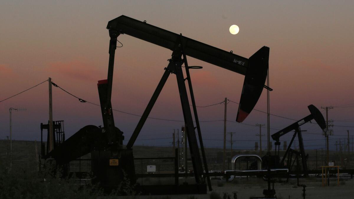 Oil derricks pump as the moon rises in Kern County.