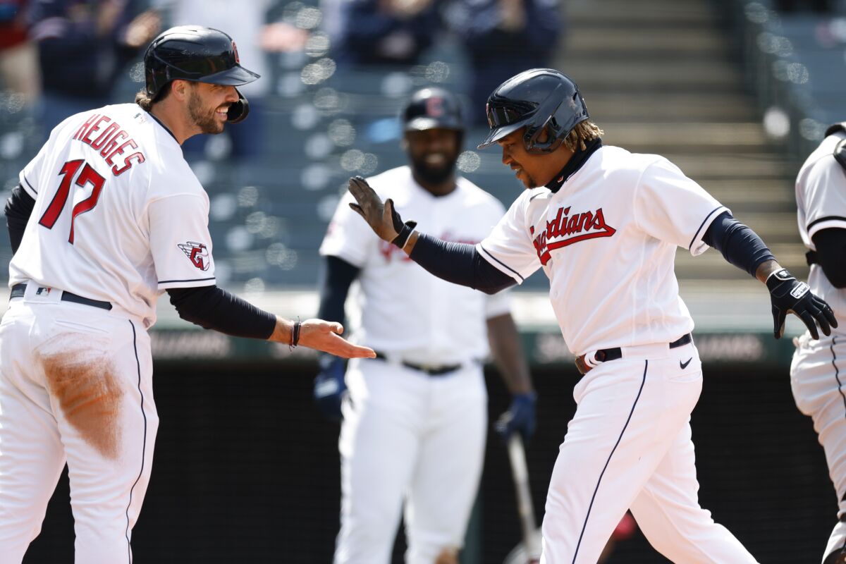 Cleveland Guardians' José Ramírez celebrates with Austin Hedges (17) after hitting a grand slam against the Chicago White Sox during the second inning in the first game of a baseball doubleheader, Wednesday, April 20, 2022, in Cleveland. (AP Photo/Ron Schwane)