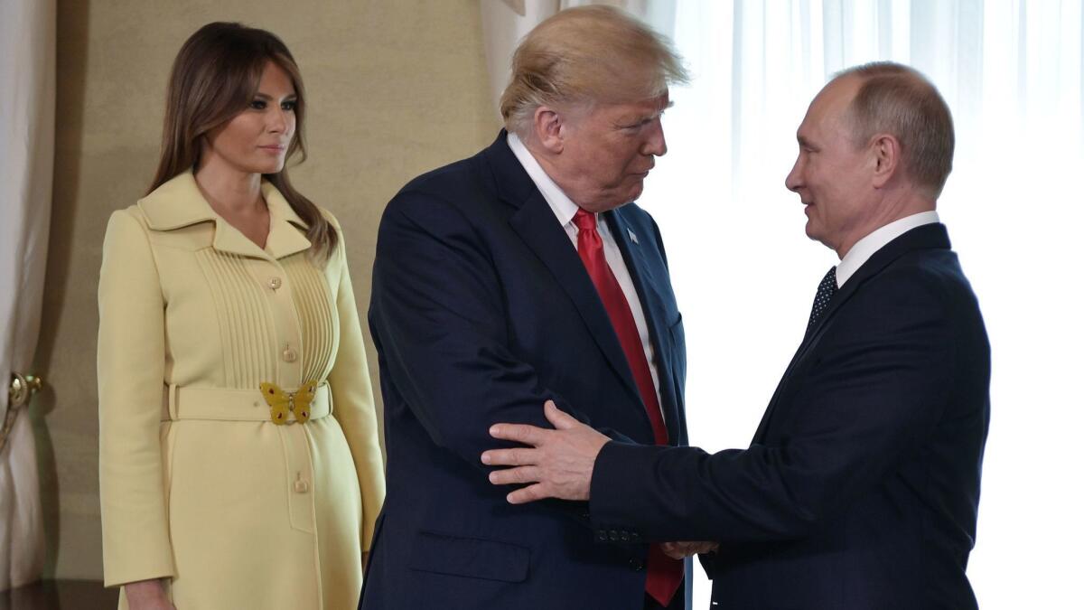 President Trump shakes hands with Russian President Vladimir Putin as First Lady Melania Trump looks on prior to the two leaders' private meeting in Helsinki, Finland, on Monday.