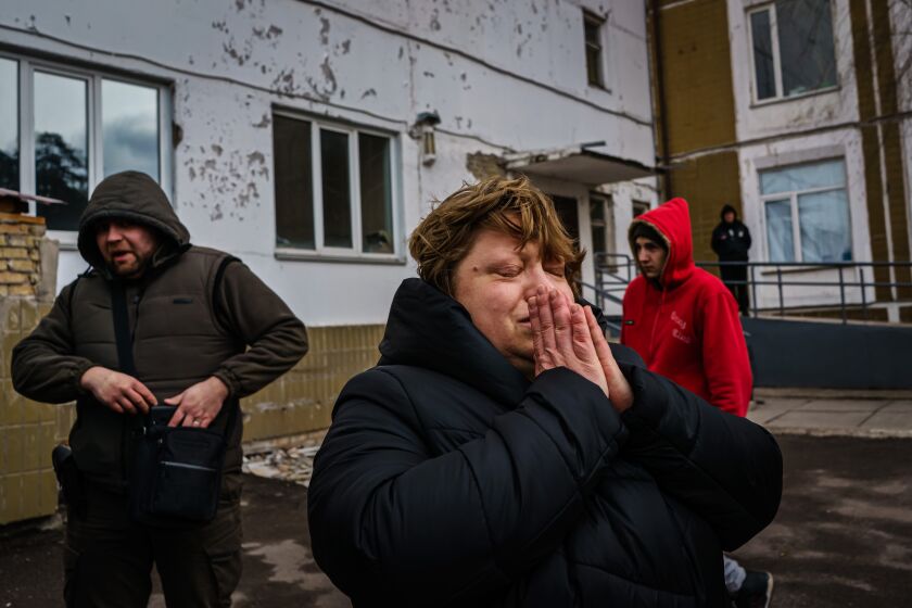 IRPIN, UKRAINE -- MARCH 4, 2022: Oksana Romaschuk, 43, puts her hands in prayer, moments before she and her family crammed into getaway cars to escape the fighting between Russian and Ukrainian forces drawing closer to Irpin, Ukraine, Friday, March 4, 2022. (MARCUS YAM / LOS ANGELES TIMES)