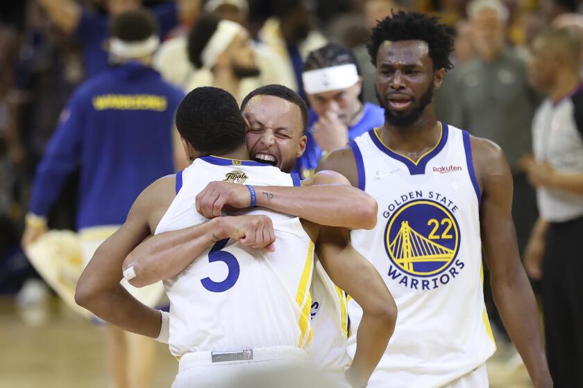 Golden State Warriors guard Jordan Poole, left, celebrates with guard Stephen Curry, middle.