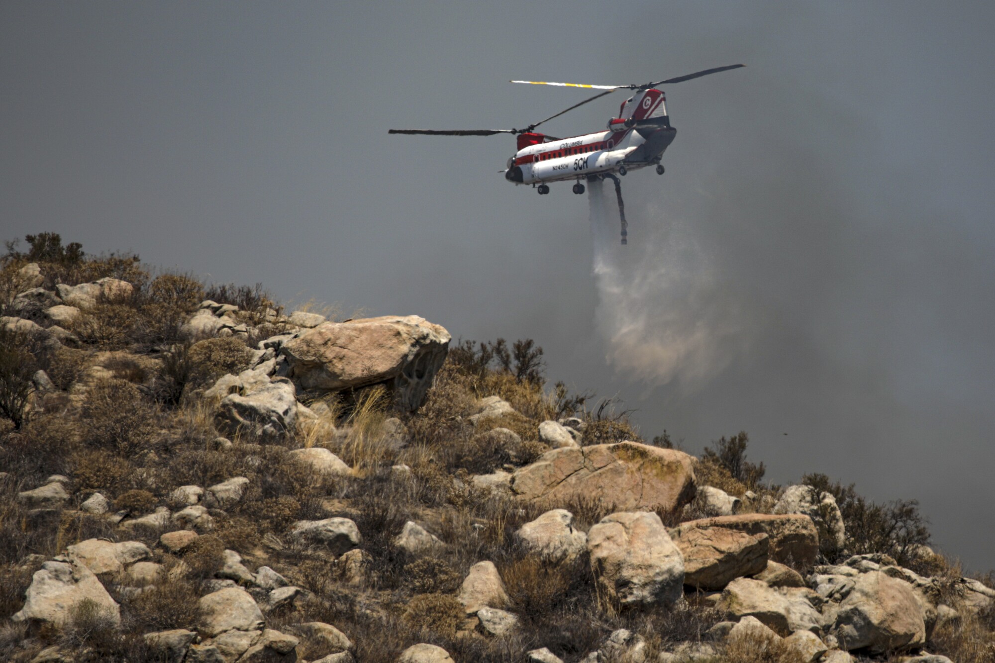 A Chinook helicopter makes a water drop  in Avery Canyon. 