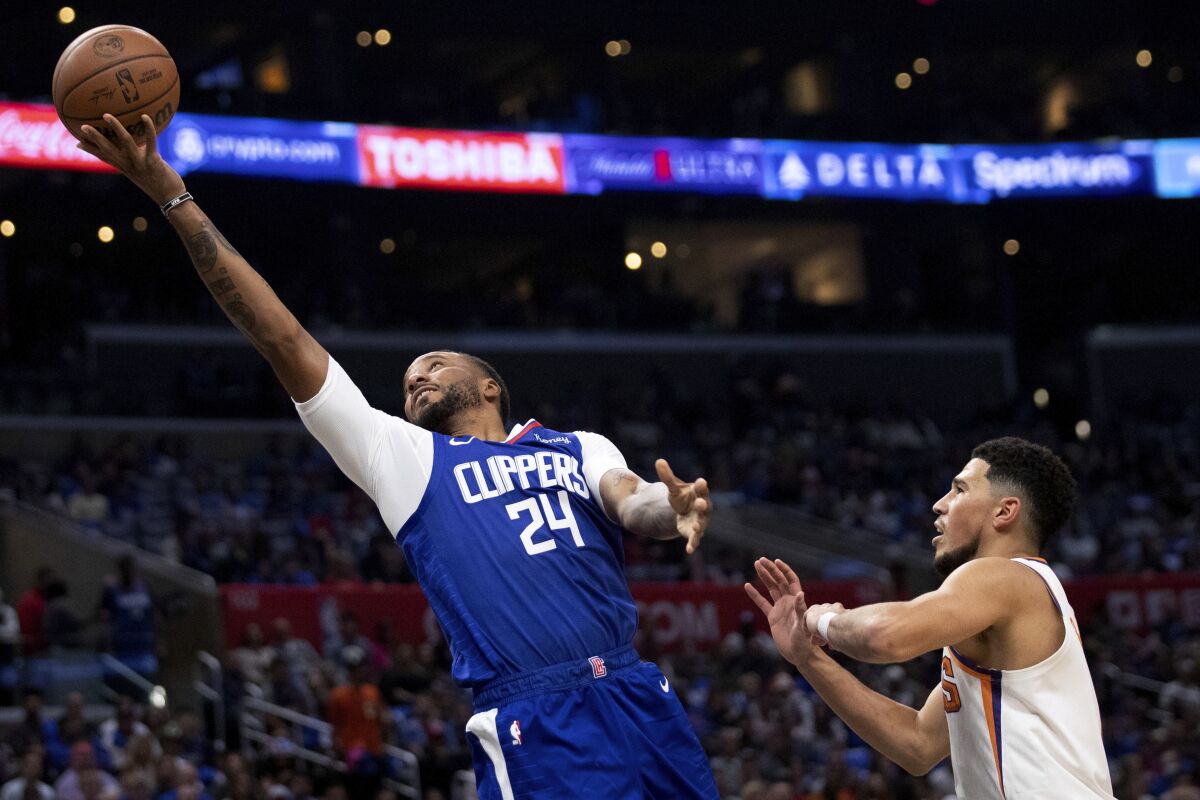 Clippers forward Norman Powell shoots against Phoenix Suns guard Devin Booker.