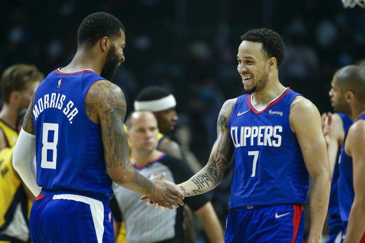 Clippers guard Amir Coffey (7) is congratulated by forward Marcus Morris Sr. after making a three-pointer Monday.