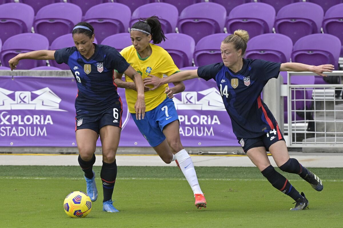 Brazil midfielder Andressa on the field with Americans Lynn Williams and Emily Sonnett.