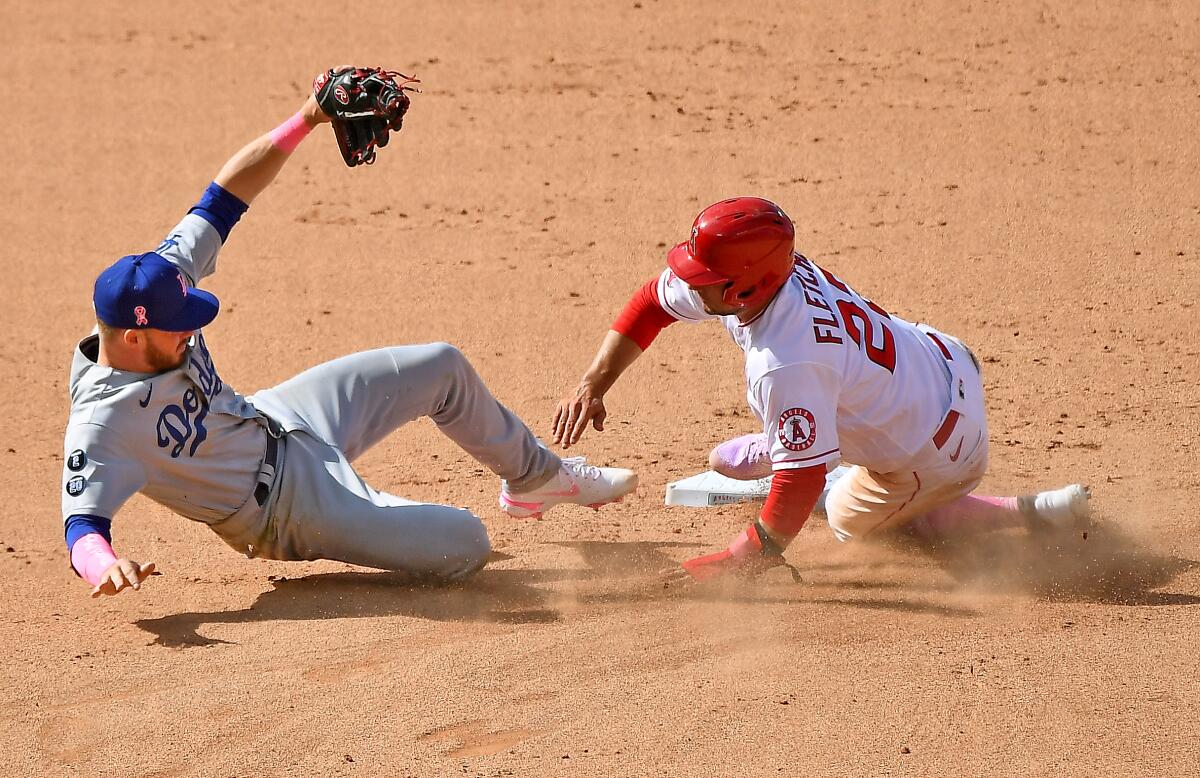 Dodgers second baseman Gavin Lux can't catch a throw, allowing Angels baserunner David Fletcher to advance to third.