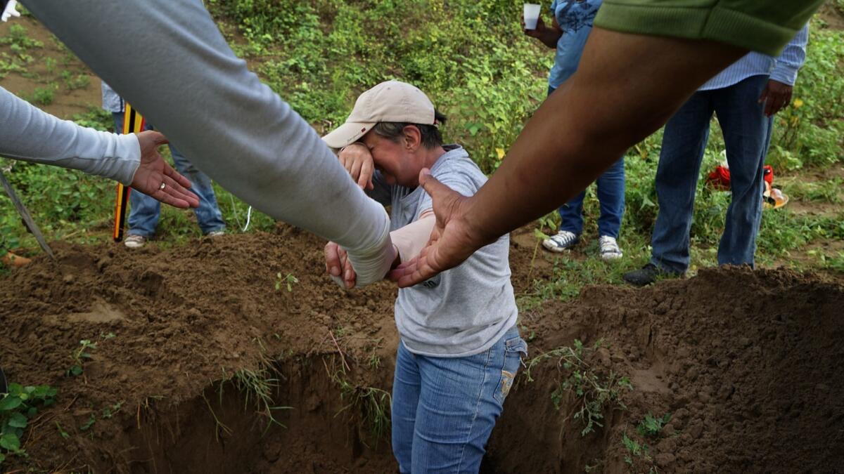 Rosalia Castro, 61, whose son disappeared in 2011, is overcome with emotion while helping to excavate a clandestine grave in Mexico's Veracruz state.