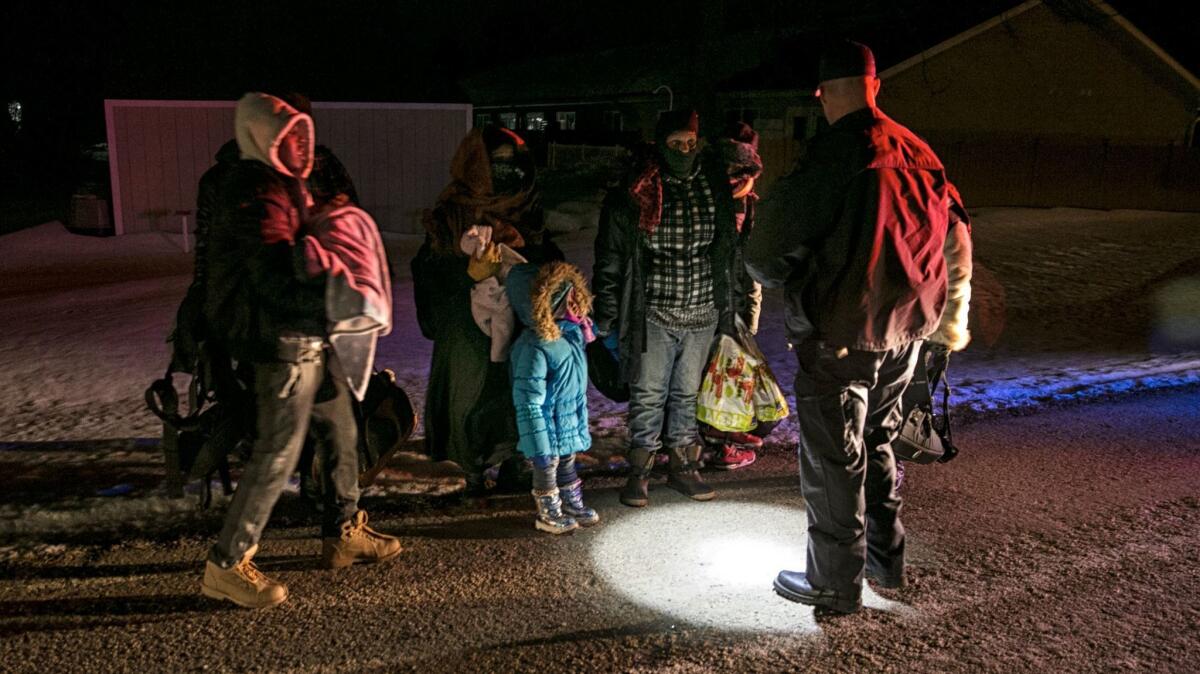 Constable Richard Graham of the Royal Canadian Mounted Police detains a group of men, women and children who crossed into Emerson, Canada, from the U.S. in the early hours of Feb. 19.