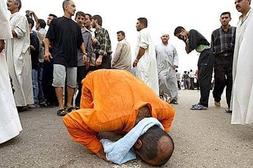 A freed Iraqi prisoner falls to his knees in prayer after his release from Abu Ghraib prison. He was one of about 600 prisoners released by the U.S. military on Friday.