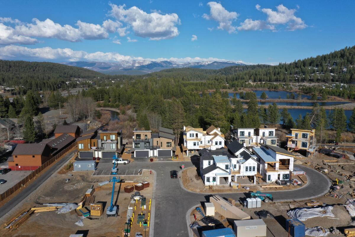 An aerial view of a housing development being built in Truckee, with lakes, forest and mountains in the background