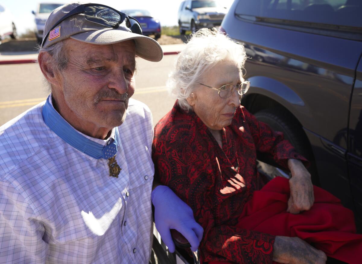 U.S. Army veteran John Baca stays at the side of Angelina Liakos, 93