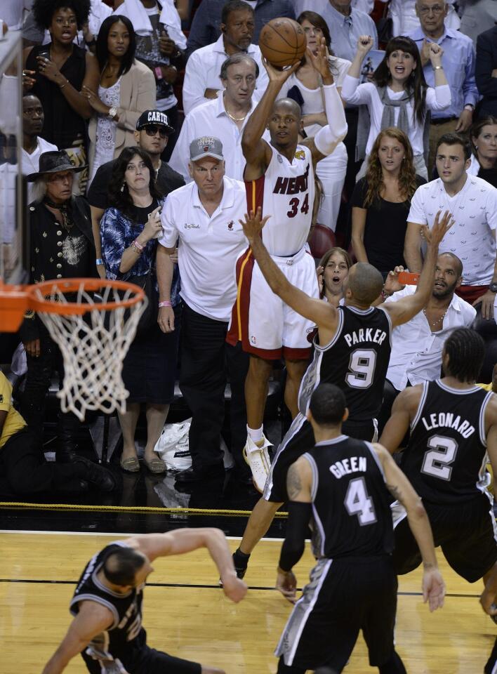 Miami Heat guard Ray Allen (34) hits a three-point jumper to tie the score and force overtime as San Antonio Spurs point guard Tony Parker (9) during the final seconds of regulation of Game 6 of the NBA Finals.