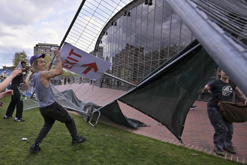 Demonstrators tear down barricades that had been erected outside a pro-Palestinian encampment atthe Massachusetts Institute of Technology, Monday, May 6, 2024, in Cambridge, Mass. Several hundred demonstrators crossed the barricades to join pro-Palestinian demonstrators that have been given a deadline to leave the encampment. (AP Photo/Josh Reynolds)