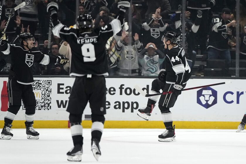 Los Angeles Kings defenseman Mikey Anderson, right, celebrates his goal with left wing Kevin Fiala, left, and right wing Adrian Kempe during the third period of an NHL hockey game against the Seattle Kraken Tuesday, Nov. 29, 2022, in Los Angeles. (AP Photo/Mark J. Terrill)