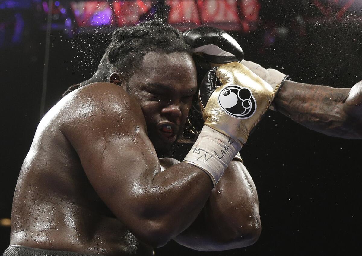 Bermane Stiverne takes a punch from Deontay Wilder during their WBC heavyweight championship bout Saturday. Stiverne was hospitalized for dehydration following the fight.
