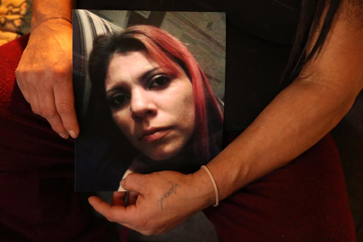 A person holds a photo of a woman.