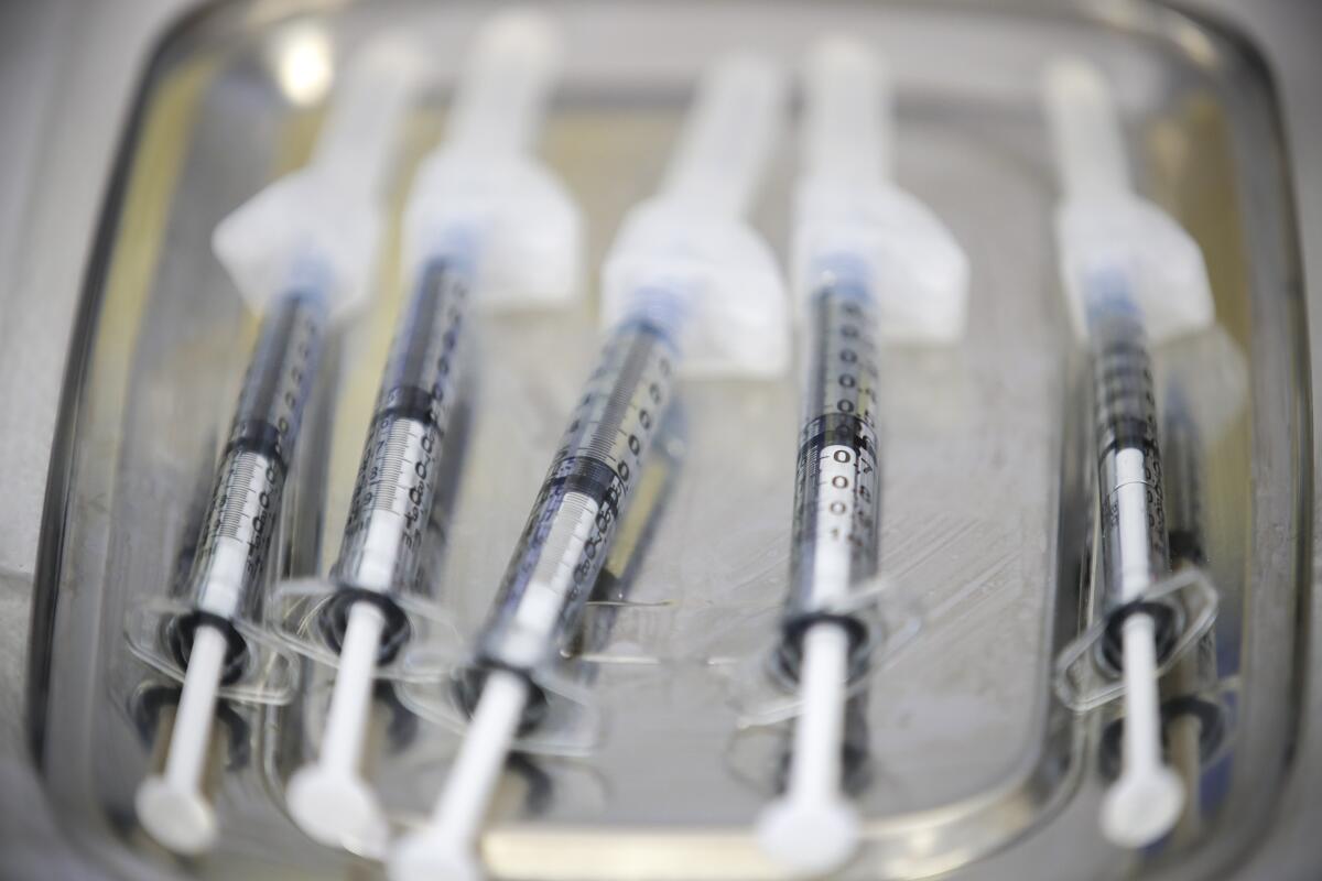 Syringes loaded with the Johnson & Johnson COVID-19 vaccine lie on a tray.