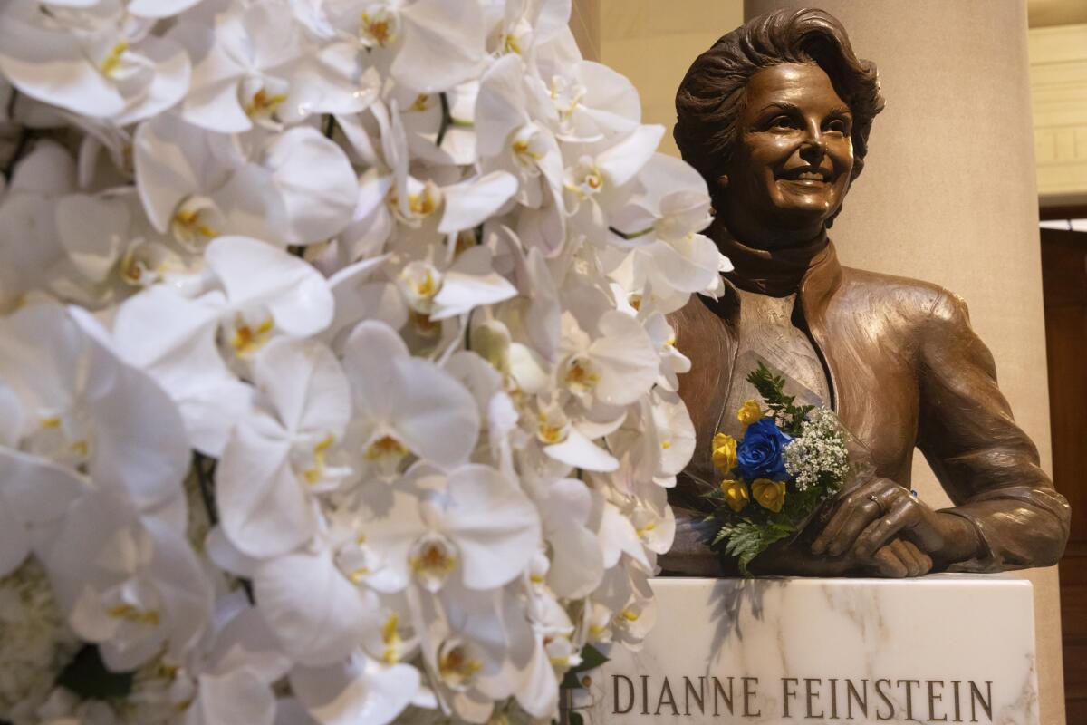 Flowers rest at a bust of U.S. Sen. Dianne Feinstein at City Hall in San Francisco. 