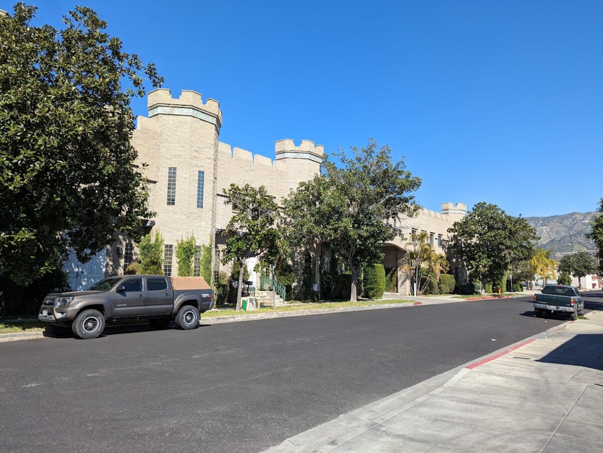A castle with several turrets sits on a tree-lined Burbank street