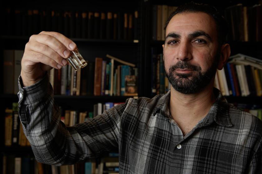 San Diego, California - September 21: Shahan Derkarabetian Ph.D., new curator of entomology at the San Diego Natural History Museum. He holds up a viles with a Opiliones also known as daddy longlegs in Balboa Park on Thursday, Sept. 21, 2023 in San Diego, California. (Alejandro Tamayo / The San Diego Union-Tribune)