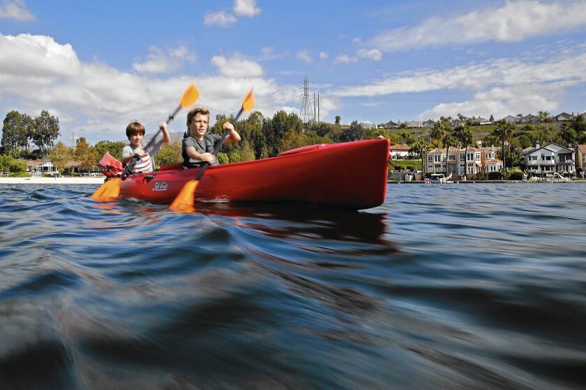 Brothers Keath and Kaiden Sahagun paddle a kayak across Lake Mission Viejo in October.