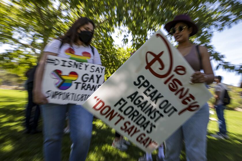 Glendale, CA - March 22: Disney's LGBTQ employees Tiffany Cooper, left, and Nicole Quadros rally against their CEO Bob Chapek's handling of the staff controversy over Florida's "Don't Say Gay" bill, at Bette Davis Picnic Area on Tuesday, March 22, 2022 in Glendale, CA. (Irfan Khan / Los Angeles Times)