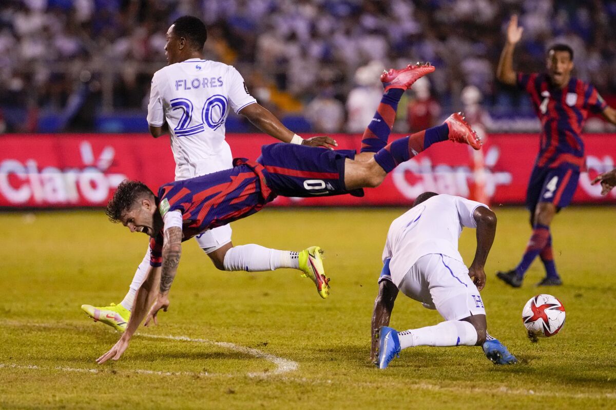 United States' Christian Pulisic is in midair after a collision with Honduras' Maynor Figueroa.