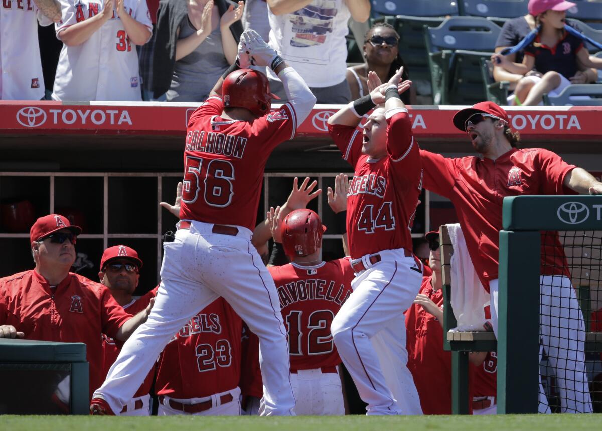 Angels outfielder Kole Calhoun (56) celebrates his second inning home run with teammate Daniel Robertson.