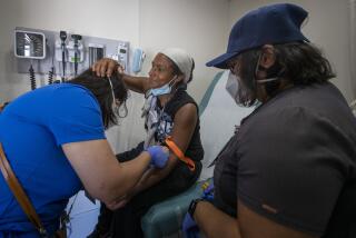 PACOIMA, CA - September 26, 2022 - Patient Yesenia Guevara, center, adjusts LVN Munisa Saidova's face mask, left, as Saidova draws blood with RN Richelle Legaspi,(CQ) right, inside a mobile medical clinic set up by the L.A. County Department of Health Services in a parking lot at Richie Valens Park Sept. 26, 2022 in Pacoima, CA. (Brian van der Brug / Los Angeles Times)