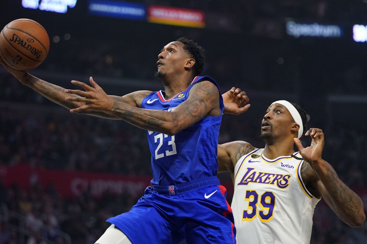 Clippers guard Lou Williams, left, shoots in front of Lakers center Dwight Howard.