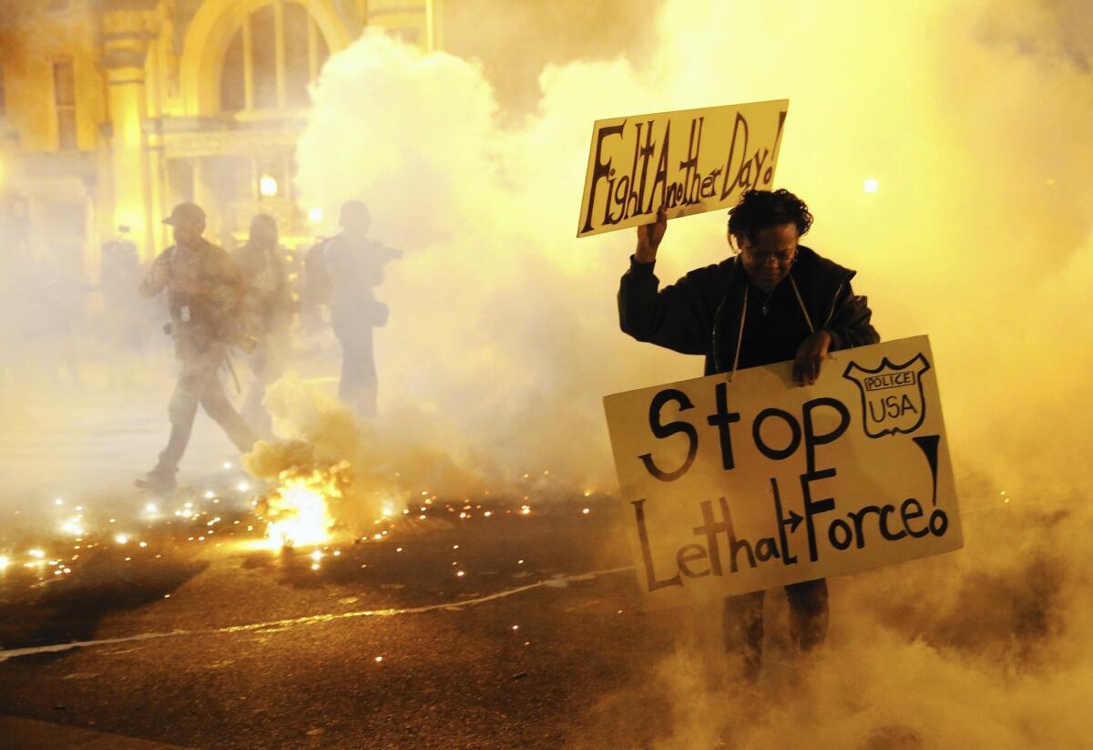 A protester flees from tear gas during this year's rioting in Baltimore. The federal government denied Maryland's request for disaster aid to assist in post-riot recovery. The governor is appealing the decision.